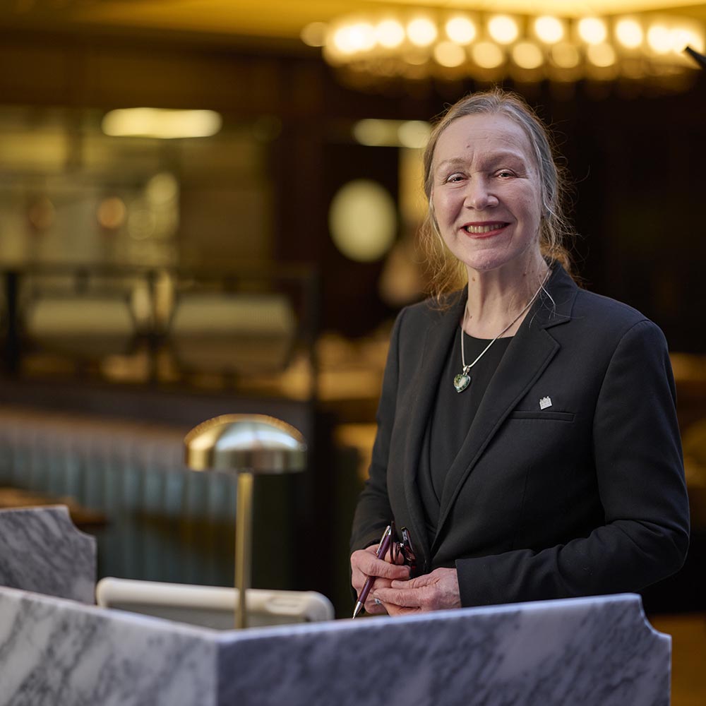 reception manager stands behind a marble desk